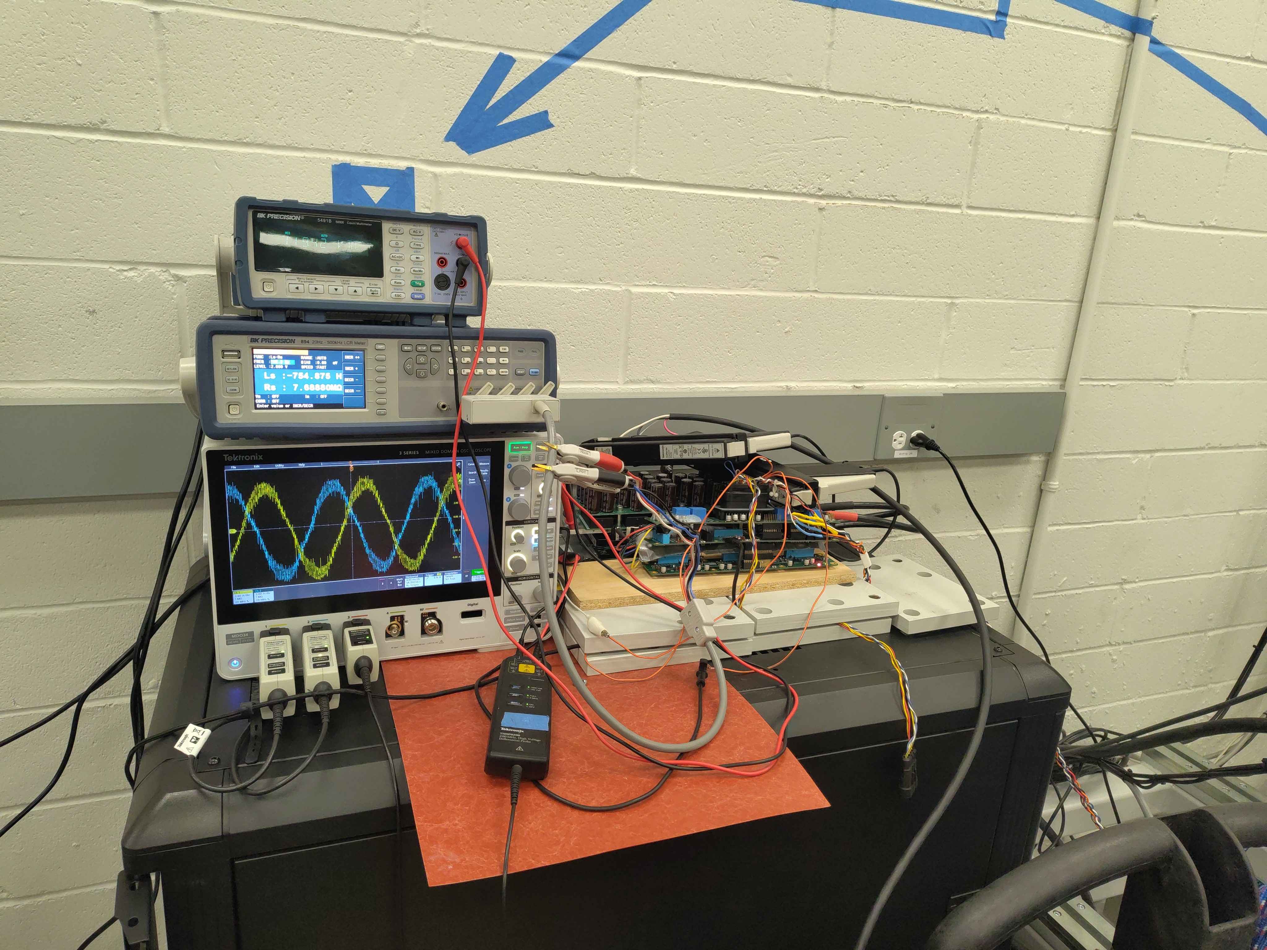 Test bench with scope, LCR meter, and C2 inverter driving the induction motor
